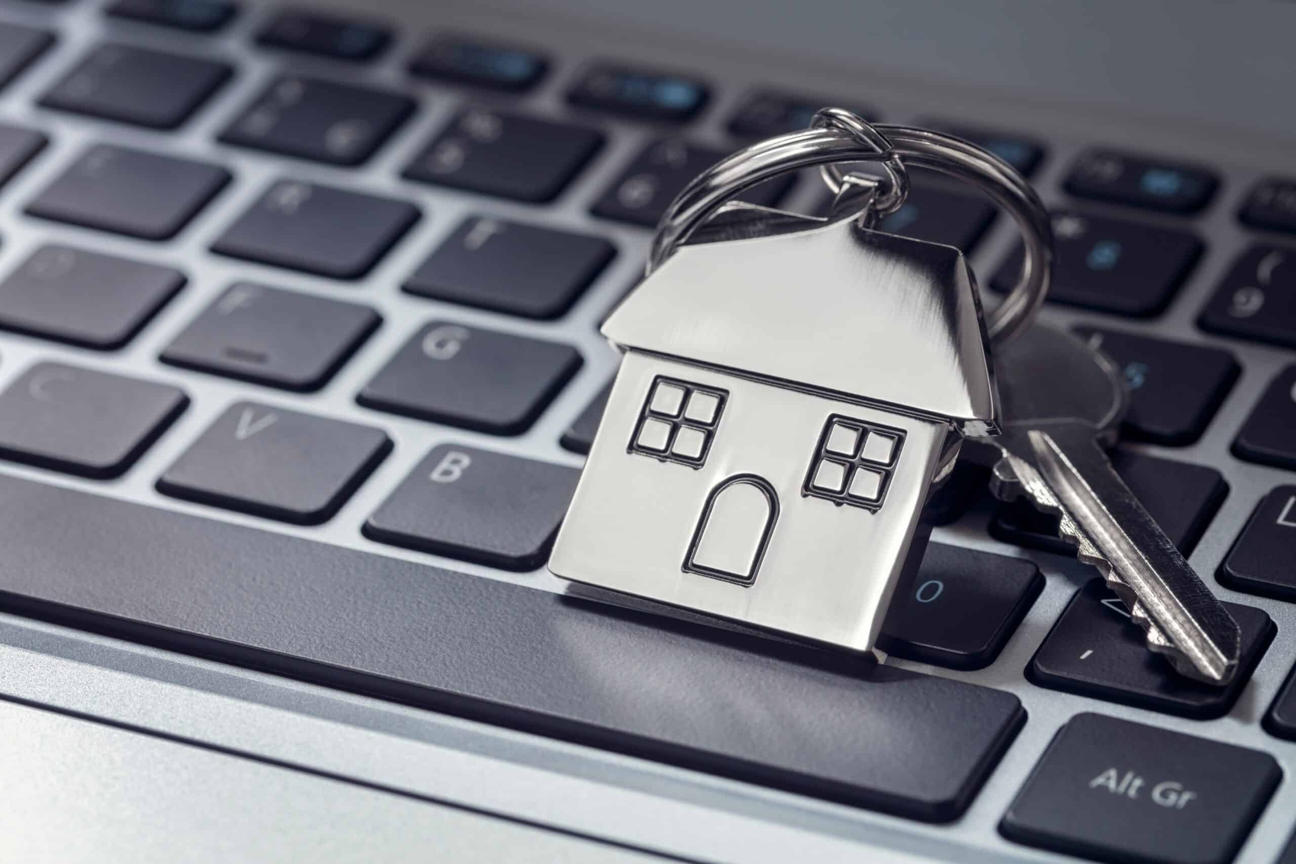House shaped keyring and keys on a laptop keyboard