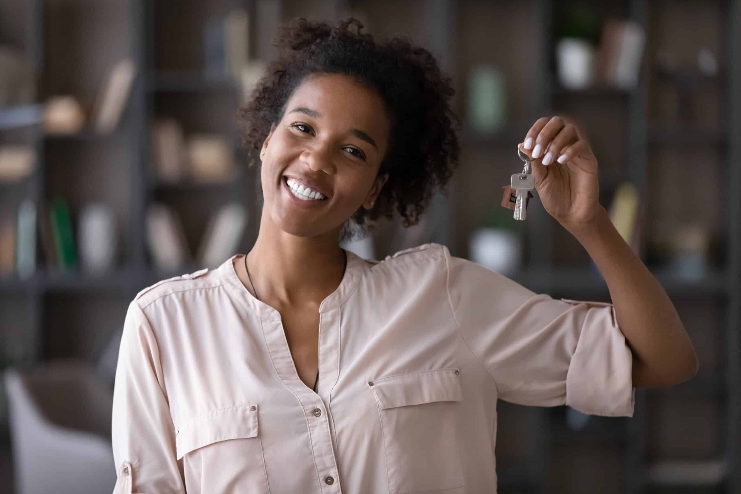Smiling woman holding up a set of house keys