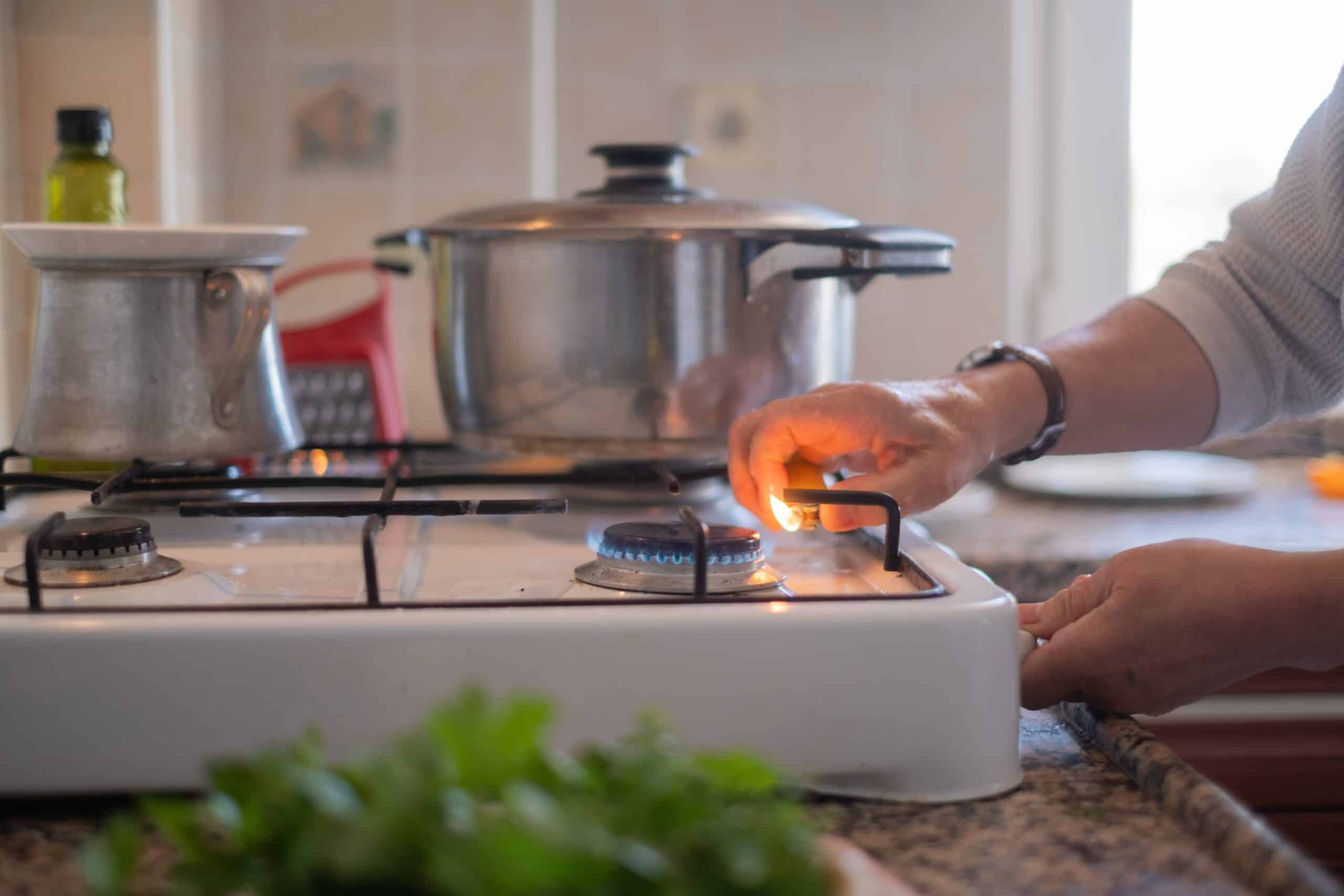 Person cooking on a lit gas hob