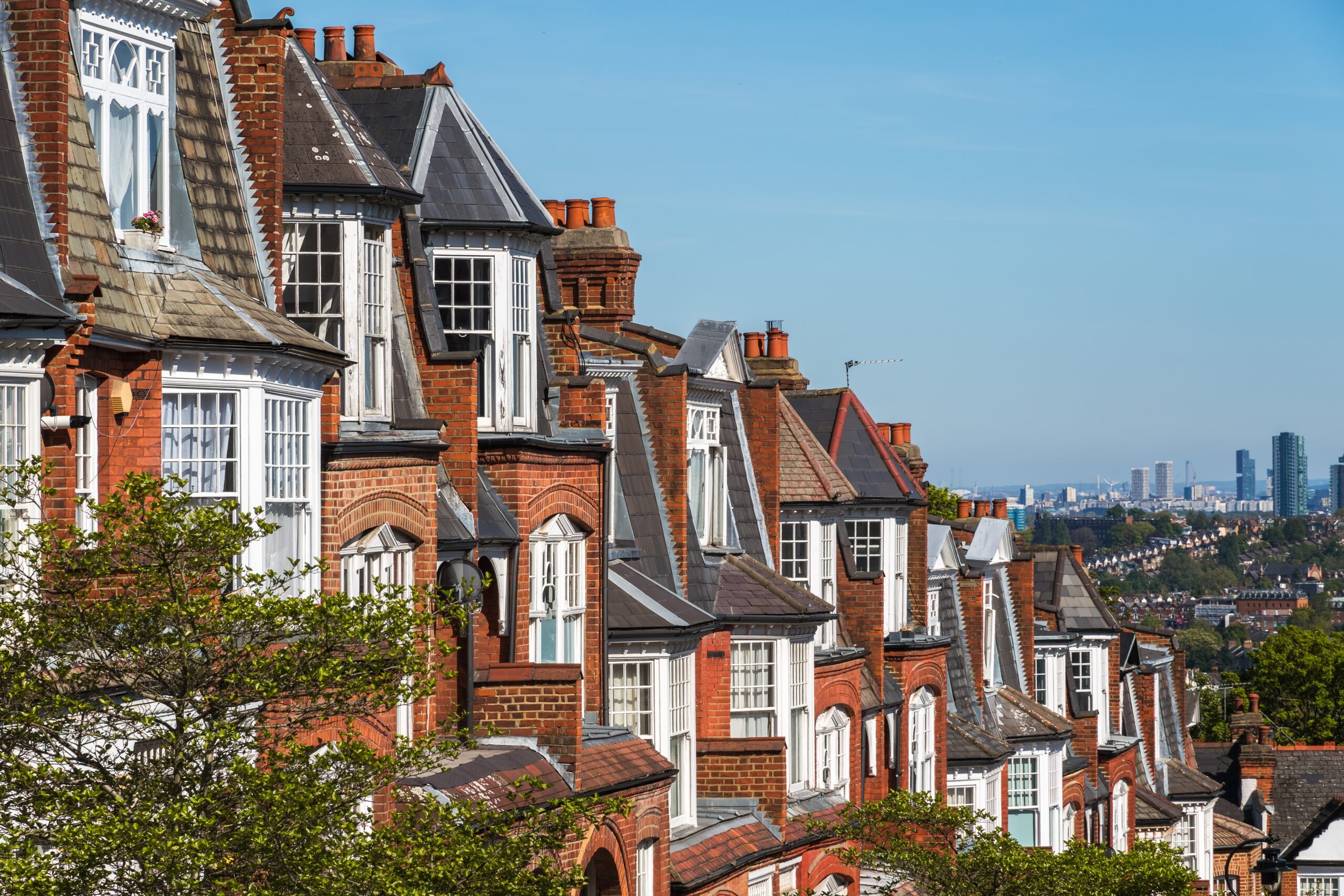 Row of Victorian terraced rooftops across a city skyline