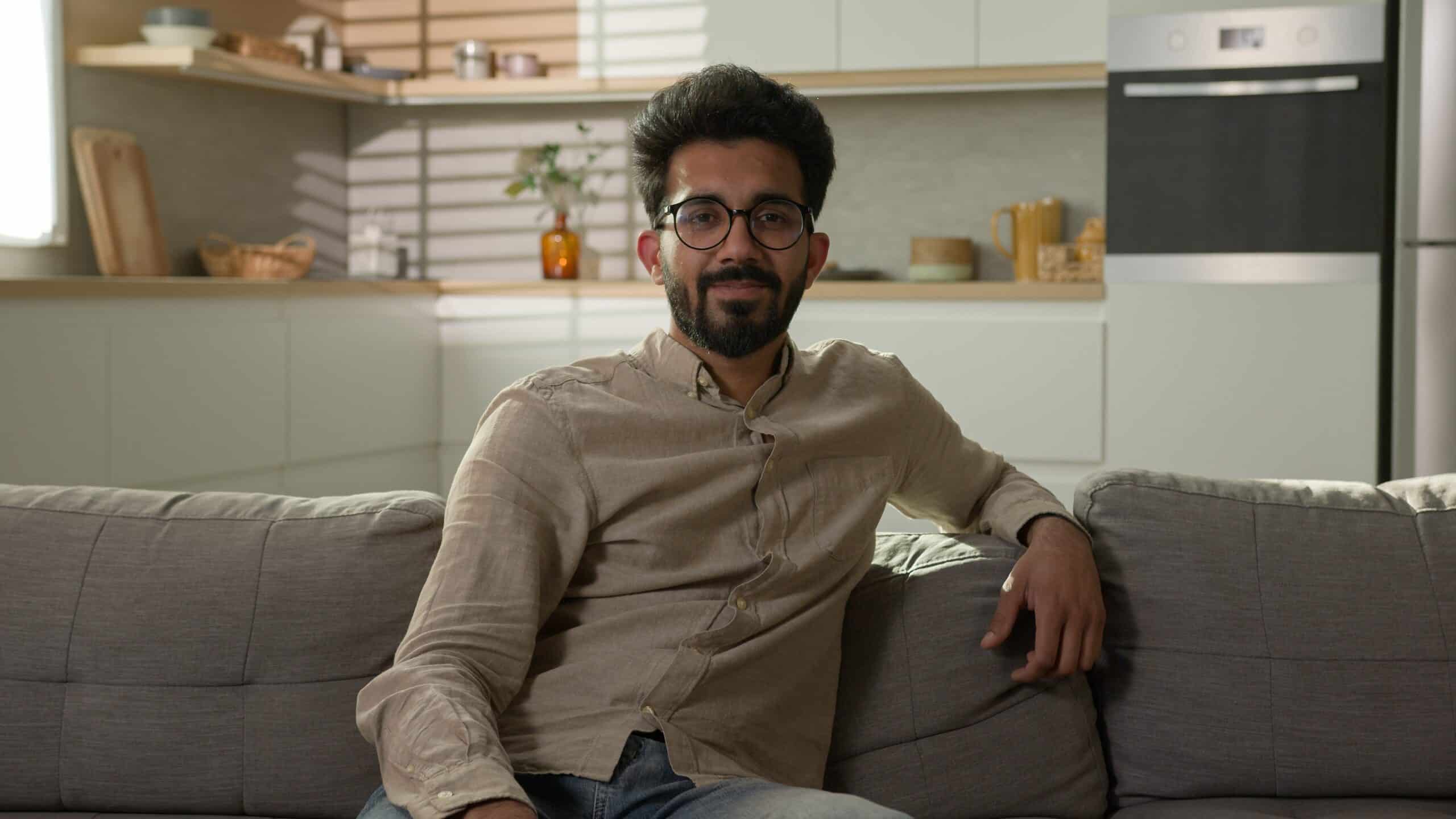 Man sitting on a sofa in a modern open plan kitchen