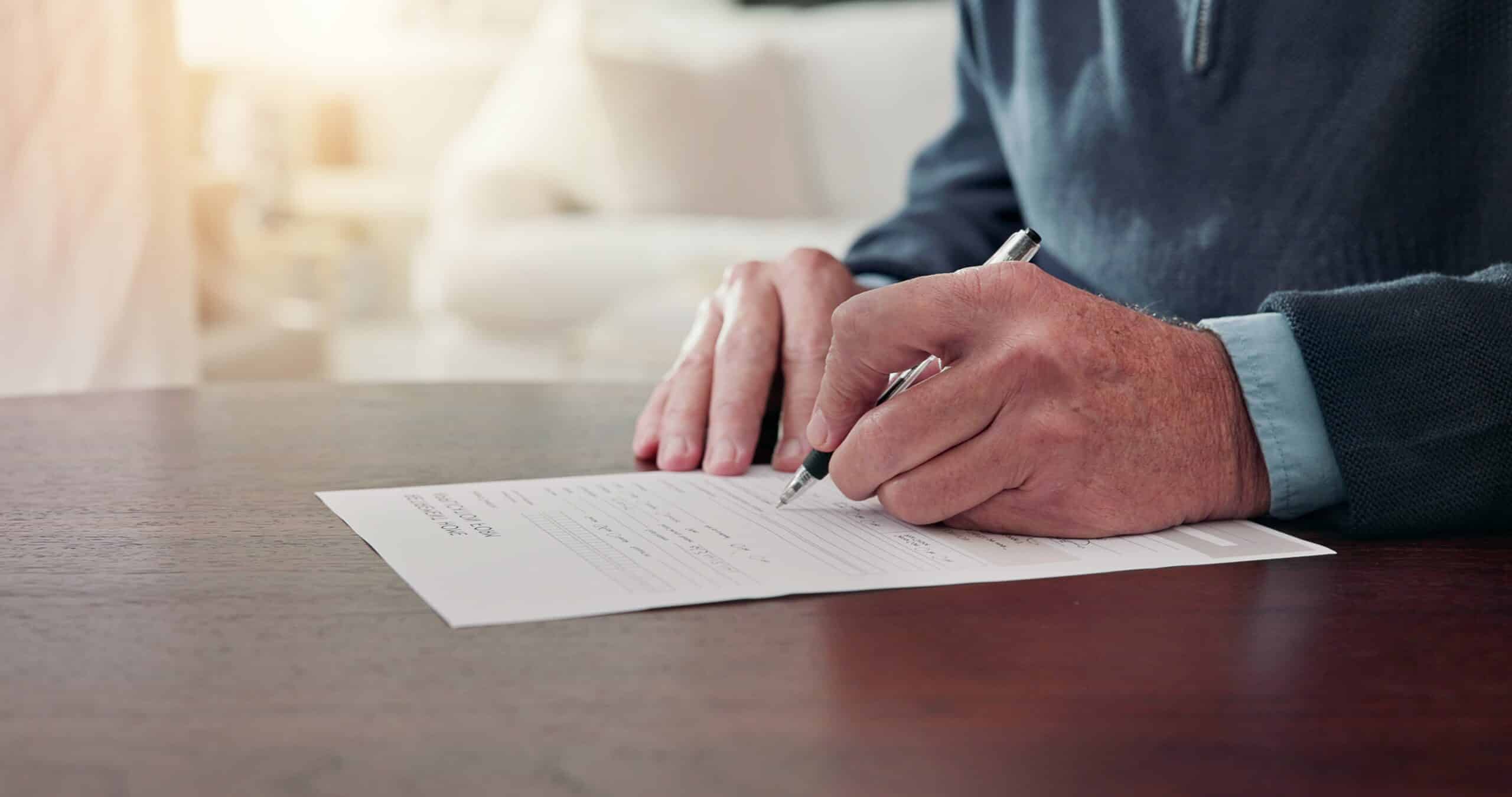 Person signing a document at a table