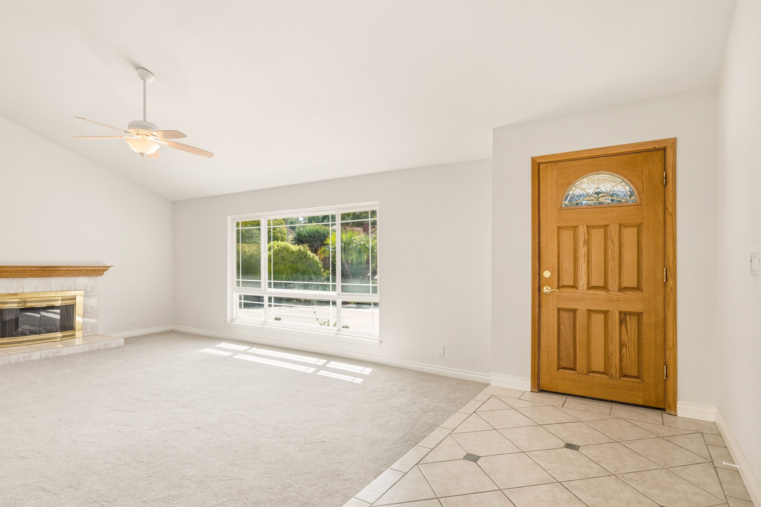Empty unfurnished living room with bare carpet and a wooden front door